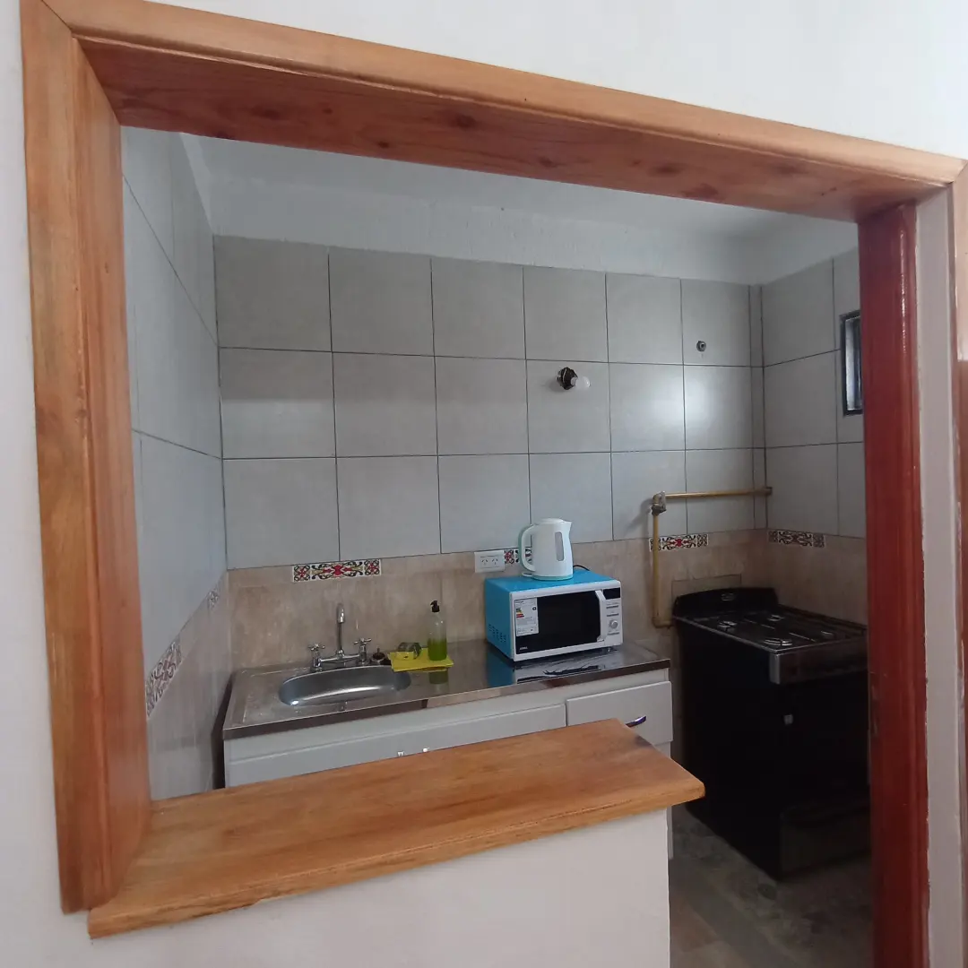 Cocina equipada con microondas, hornallas y pava eléctrica